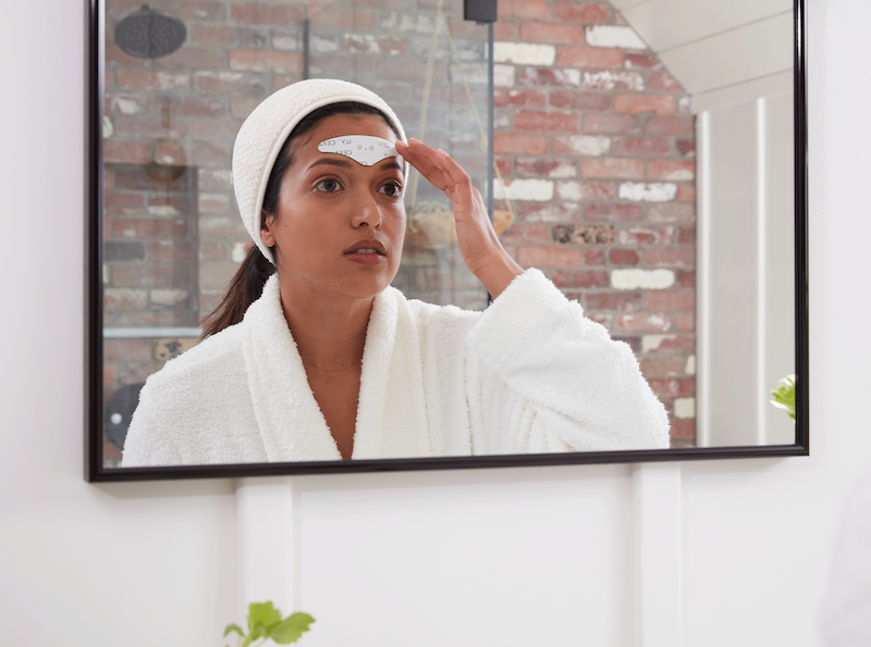 Lady placing self-adhesive electrode on head